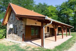 a small stone house with a red roof at Feketebács Nyaralóház in Káptalantóti