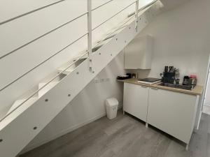 a kitchen with white cabinets and stairs with a sink at Viva Residence in Calderara di Reno