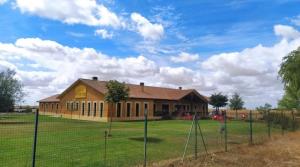 a house on a field with a fence at Albergue Los Templarios in Terradillos de Templarios