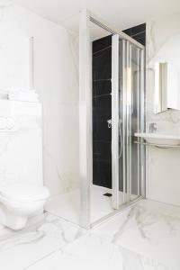 a white bathroom with a shower and a toilet at Ibis budget Périgueux in Périgueux