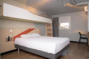 a bedroom with a large white bed and a window at Ibis budget Périgueux in Périgueux