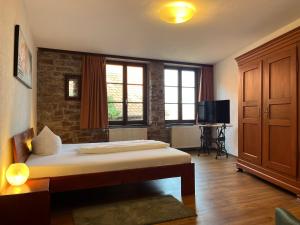 ein Schlafzimmer mit einem Bett und einem Fernseher in der Unterkunft Hotel Weingärtner in Mannheim