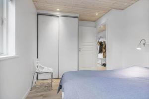 a bedroom with a bed and a chair and a closet at OH532-Hadsund-Avaenget-14 in Hadsund