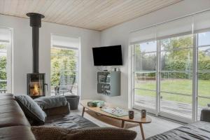 a living room with a couch and a tv and windows at OH532-Hadsund-Avaenget-14 in Hadsund