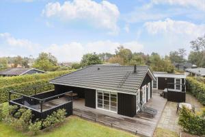 a house with a black roof and a patio at OH532-Hadsund-Avaenget-14 in Hadsund