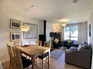a dining room and living room with a table and chairs at Silver Birch Cottage in Aviemore