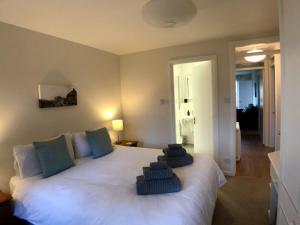 a bedroom with a large white bed with towels on it at Silver Birch Cottage in Aviemore