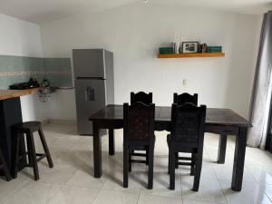 a kitchen with a table and chairs and a refrigerator at Loft zona centro La Merced in San Cristóbal de Las Casas
