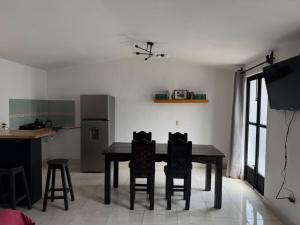 a kitchen with a table and chairs and a refrigerator at Loft zona centro La Merced in San Cristóbal de Las Casas