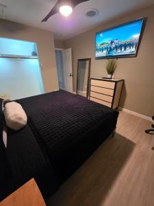 a bedroom with a bed and a flat screen tv at Modern Retro 2BR Condo in High Point