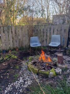 two chairs and a fire pit next to a fence at Hilltop Lodge in Cultra +8 photos