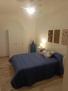 a bedroom with a blue bed and a ceiling fan at Mediterraneo in Vinarós