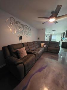 a living room with a brown couch and a ceiling fan at Modern Retro 2BR Condo in High Point