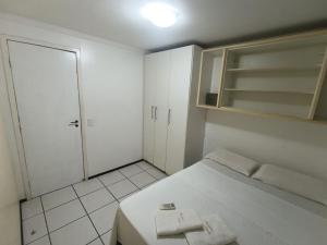 a white room with a bed and a closet at Porto de Iracema Vista Mar in Fortaleza