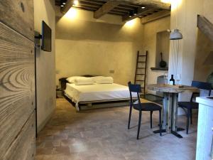 a bedroom with a bed and a table and chairs at Piazza San Donato Casa Vacanze in Bagnoregio +31 photos