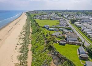 an aerial view of a beach with houses at Lapwing 26 in Scratby