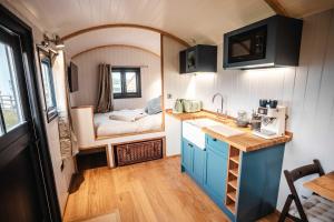 a kitchen with a sink and a room with a bed at Shepherds View in Ashbourne