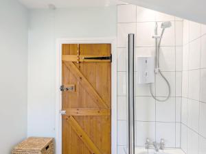 a bathroom with a shower and a wooden door at Vane Cottage - Lewes in Lewes +23 photos