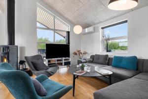 a living room with a couch and chairs and a tv at OH543-Hadsund-Haslevgarde-eng-16 in Hadsund