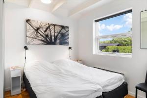 a white bedroom with a bed and two windows at OH543-Hadsund-Haslevgarde-eng-16 in Hadsund
