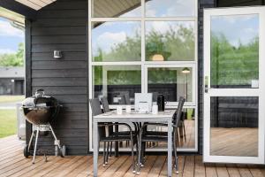 a table and chairs on a patio with a large window at OH543-Hadsund-Haslevgarde-eng-16 in Hadsund