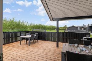 a patio with a table and chairs on a wooden deck at OH543-Hadsund-Haslevgarde-eng-16 in Hadsund