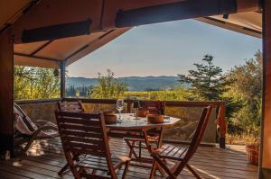 a table and chairs on a deck with a view at Camping la Peiriere - Lodge en Pays Cathare in Tuchan