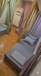 a bed in a room with curtains on it at Thai Nee Homestay in Manila
