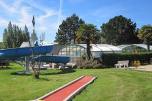 a blue boat statue in a park next to a building at Camping Paradis les Capucines in Trédrez