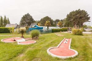 a playground with two trays in the grass at Camping Paradis les Capucines in Trédrez +2 photos