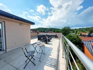 a patio with chairs and tables on a balcony at GFS way studios - greenline accomodation in Ljubljana