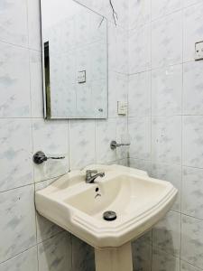 a white bathroom with a sink and a mirror at The Layover Hostel in Katunayaka +22 photos