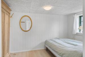 a bedroom with a bed and a mirror on the wall at 722-Thyboron-Vesterhavsgade-144 in Thyborøn