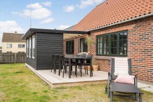 a deck with a table and chairs on a house at 722-Thyboron-Vesterhavsgade-144 in Thyborøn