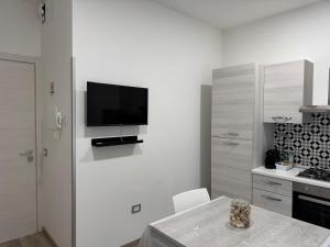 a white kitchen with a television on a wall at EDEL Vacation Home in Terni