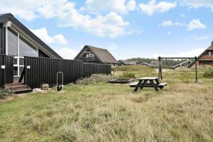 a picnic table in a yard next to a house at 313-Harboore-Fourmivej-68 in Harboør