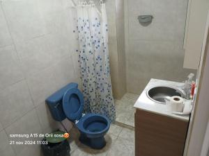 a bathroom with a blue toilet and a sink at Cabaña Doña Adela in Paso de la Patria +2 photos