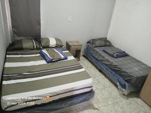 two twin beds in a room withthritisthritisthritisthritisthritisthritisthritisthritisthritis at Cabaña Doña Adela in Paso de la Patria