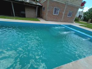 a pool of water in front of a house at Cabaña Doña Adela in Paso de la Patria