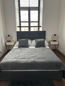 a bedroom with a large bed with a large window at Apartamenty Łuczkowskiego z widokiem na Stary Rynek i Studnie 1 102m2 in Chełm