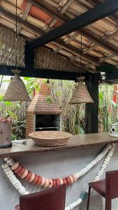a patio with a table with a fireplace and chairs at Janaína Picinguaba in Ubatuba