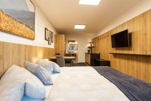 a bedroom with a bed and a flat screen tv at Studio Toblaten in Inzing