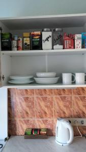 a shelf with plates and bowls on it at Central Point Apartments in Rēzekne +1 photo