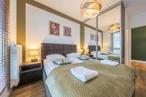 a bedroom with a large bed and a mirror at Comfort Apartments Batorego in Gdynia