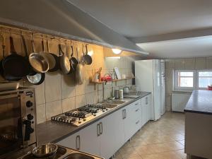 a kitchen with white cabinets and a stove top oven at Pokoje Agroturystyka Koczy Zamek in Koniaków