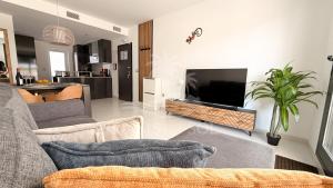 a living room with a couch and a tv in a room at Sunny Place Oasis del Sol in Arenales del Sol