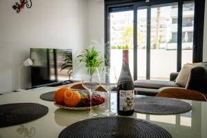 a table with two glasses of wine and a bowl of fruit at Sunny Place Oasis del Sol in Arenales del Sol