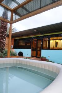 a house with a swimming pool and a bus at תחנת גן עדן - Paradise Station in Menaẖemya
