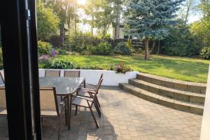a patio with a table and chairs and a garden at 3 Rooms Garden Parking in Raszyn