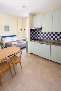 a kitchen with two beds and a table and chairs at Bellariva appartamenti in Rimini